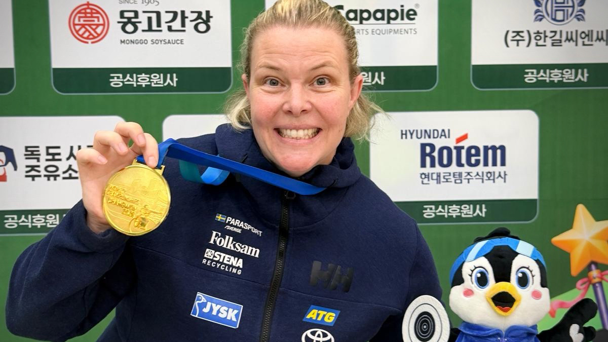 Anna Benson ler mot kameran och håller upp sin guldmedalj.
